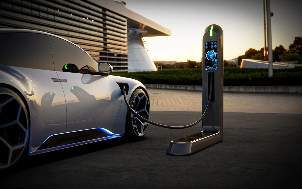 An electric car plugged into a charge point at dusk
