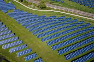 Rows of solar panels across green fields